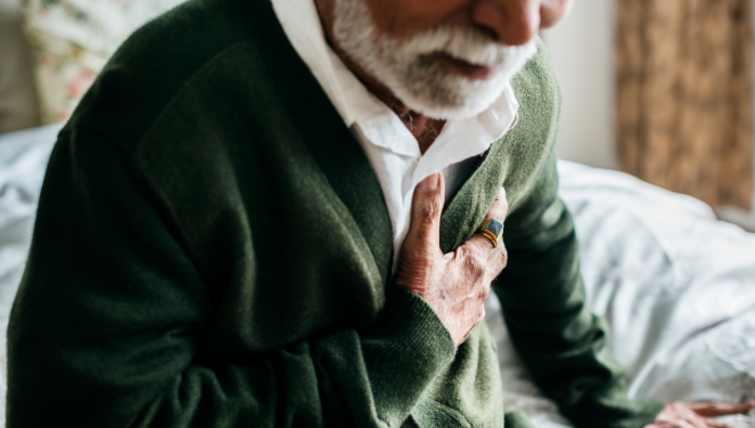 A man clutching his chest as if he is having a heart attack A man clutching his chest as if he is having a heart attack
