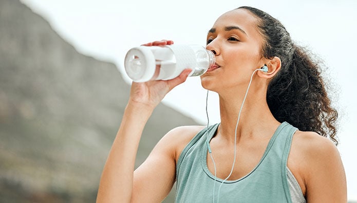 A woman working out and drinking water A woman working out and drinking water
